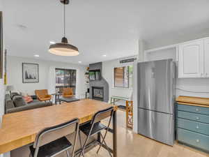 Kitchen featuring freestanding refrigerator, open floor plan, white cabinetry, healthy amount of natural light, and recessed lighting