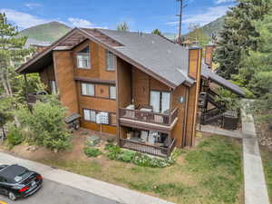 Back of property with roof with shingles, a chimney, stairway, and a mountain view