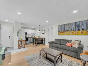 Living room with recessed lighting and light wood-type flooring