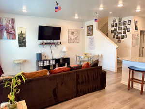 Living room with light wood-style flooring and stairway