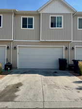View of property exterior featuring an attached garage, driveway, and board and batten siding