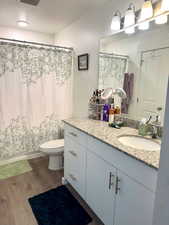 Bathroom with vanity, wood finished floors, and curtained shower