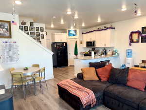 Living room with light wood-style flooring and recessed lighting