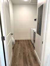 Laundry area featuring separate washer and dryer, wood finished floors, and electric panel