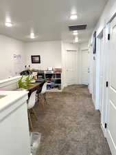 Carpeted office with a textured ceiling