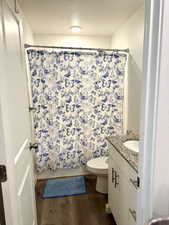 Full bath with wood finished floors, vanity, and a textured ceiling