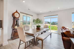 Dining room with light wood-style floors and recessed lighting