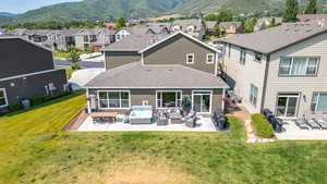 Back of house with an outdoor living space, a residential view, a shingled roof, and a patio area