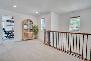 Hallway with a desk, carpet flooring, a textured ceiling, and recessed lighting