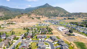 Aerial view of property and surrounding area featuring nearby suburban area and mountains