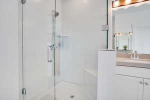 Full bath featuring a stall shower and vanity