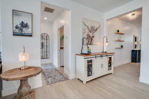 Hall with light wood-style floors and recessed lighting