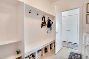 Mudroom featuring separate washer and dryer and light wood-type flooring