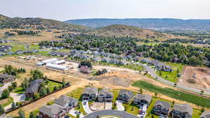 Aerial view of property and surrounding area with nearby suburban area