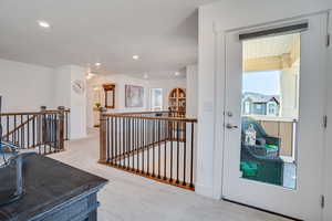 Corridor with an upstairs landing, carpet, and recessed lighting
