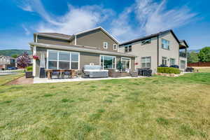 Back of property featuring a patio area, an outdoor hangout area, and a yard
