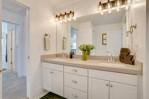 Full bath with double vanity and baseboards