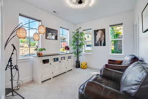 Living area with light colored carpet and baseboards