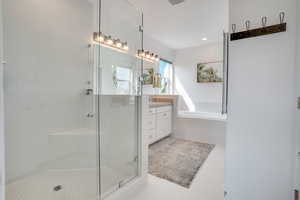 Bathroom with vanity, a stall shower, a bath, and tile patterned floors