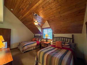 Carpeted bedroom with wooden ceiling, lofted ceiling, and ceiling fan