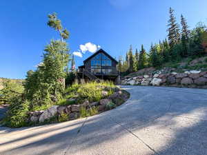 View of front of house featuring concrete driveway and a wooden deck