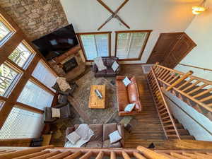 Living room featuring a high ceiling, a fireplace, and plenty of natural light