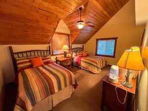 Carpeted bedroom with wood ceiling, lofted ceiling, and a ceiling fan