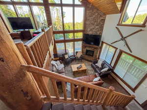 Living room featuring healthy amount of natural light, wooden ceiling, a fireplace, and high vaulted ceiling