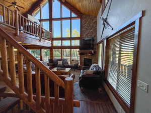 Living area with wooden ceiling, a fireplace, and high vaulted ceiling