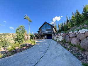 View of front of home featuring a carport, stairs, and driveway