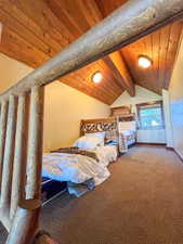 Bedroom with wooden ceiling and light carpet