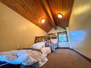 Bedroom with wood ceiling and carpet