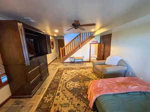 Living area featuring stairway and ceiling fan