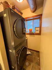 Laundry area with stacked washer / dryer and baseboards