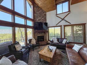 Living area featuring wooden ceiling, high vaulted ceiling, and a fireplace