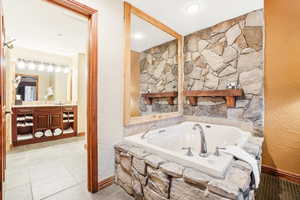 Full bathroom with vanity, a bath, and tile patterned floors