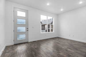 Foyer entrance with dark wood-type flooring and recessed lighting