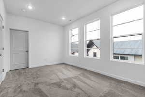 Carpeted empty room featuring baseboards and recessed lighting