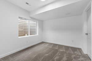 Carpeted spare room with baseboards