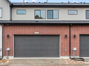 Back of property featuring brick siding and a garage