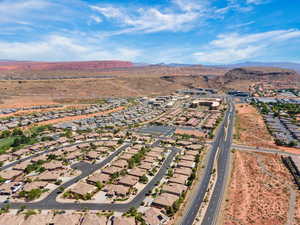 Aerial view of property and surrounding area with nearby suburban area and mountains