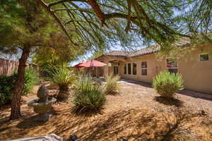 Rear view of property with stucco siding and a tiled roof