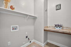 Laundry area with washer hookup, electric dryer hookup, gas dryer hookup, and light tile patterned flooring