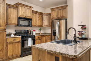 Kitchen featuring black appliances, brown cabinets, and light tile patterned floors