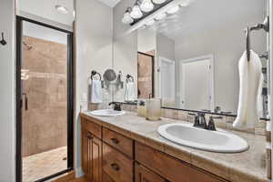 Bathroom featuring a stall shower and double vanity