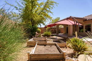View of yard featuring a vegetable garden and a patio area