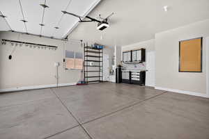 Garage with baseboards and a garage door opener