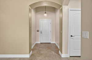 Foyer featuring light tile patterned flooring and arched walkways
