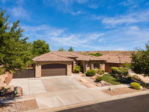 Mediterranean / spanish home with stucco siding, driveway, a garage, and a tiled roof