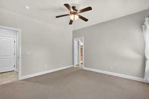 Unfurnished bedroom with light colored carpet and ceiling fan